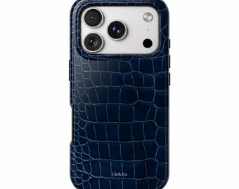 Può includere: Una custodia per telefono blu scuro con una trama in pelle di coccodrillo. La custodia presenta un ritaglio rettangolare per la fotocamera e la parola Gioletta stampata in bianco vicino al bordo inferiore del pannello posteriore.