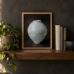 Moon jar print in the 8x10 inch size on a dark wooden shelf with books and a plant; the frame shown is not included.