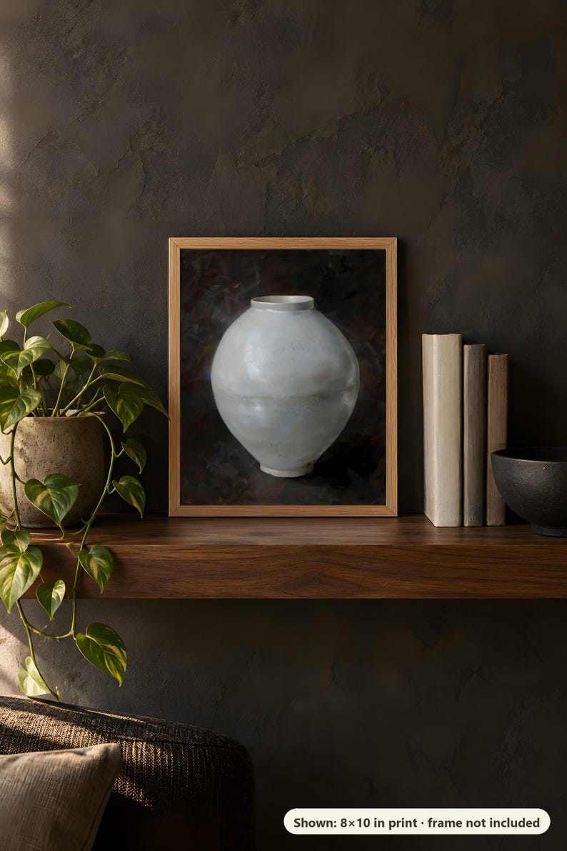 Moon jar print in the 8x10 inch size on a dark wooden shelf with books and a plant; the frame shown is not included.