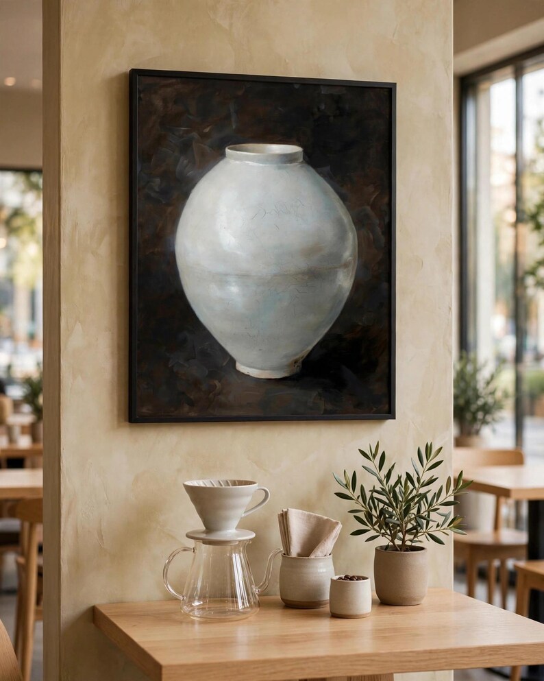 Moon jar print shown framed on a cream wall above a cafe table with ceramic pour-over coffee ware (digital room mockup).