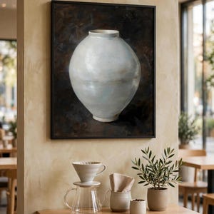 Moon jar print, one of the six set designs, shown framed above a cafe table (digital room mockup).