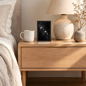 Plum blossom design printed in the 4x6 inch size on a bedside table next to a ceramic lamp; the frame shown is not included.