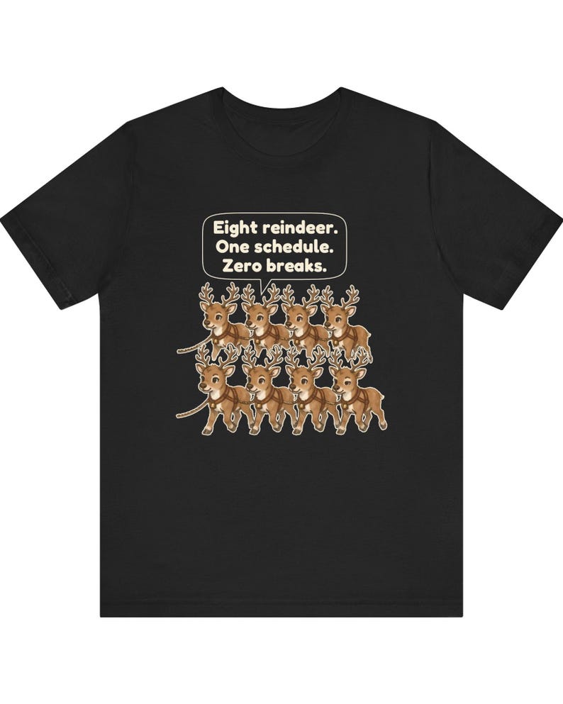 K&ouml;nnte beinhalten: Ein schwarzes kurz&auml;rmeliges T-Shirt mit einer Grafik von acht braunen Rentieren, die in zwei Reihen angeordnet sind. &Uuml;ber den Rentieren befindet sich eine wei&szlig;e Sprechblase mit dem Text: Eight reindeer. One schedule. Zero breaks.