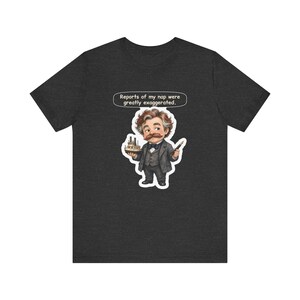 Watercolor chibi Mississippi riverboat author with a bushy moustache, navy bow tie and charcoal suit, holding a model riverboat and a fountain pen, with the speech bubble "Reports of my nap were greatly exaggerated." printed on a tee