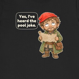 May include: A black t-shirt featuring a cartoon illustration of a bearded character wearing a red cap and green coat, holding a map. A speech bubble above the character contains the text: Yes, I've heard the pool joke.