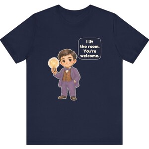 Może przedstawiać: Granatowy t-shirt z rysunkową ilustracją osoby w fioletowym garniturze i brązowej kamizelce, trzymającej świecącą żar&oacute;wkę. Dymek z tekstem zawiera napis: I lit the room. You're welcome.