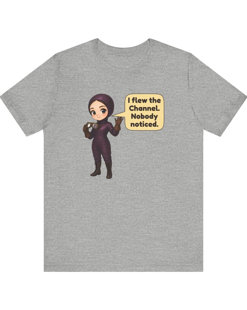 Puede incluir: Una camiseta gris jaspeado con un personaje de dibujos animados con un traje morado y gafas. Un globo de texto junto al personaje contiene el texto: I flew the Channel. Nobody noticed.