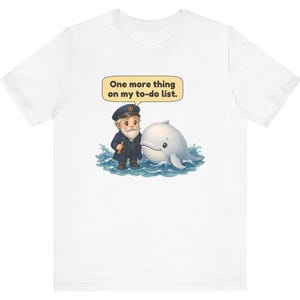 May include: A white t-shirt featuring a graphic of a bearded sea captain in a navy uniform standing in blue ocean waves next to a white whale. A yellow speech bubble above the captain contains the text, One more thing on my to-do list.