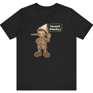 K&ouml;nnte beinhalten: Ein schwarzes Kurzarm-T-Shirt mit einer Grafik einer Holzpuppe mit langer Nase, die einen Hut, ein Hemd und eine kurze Hose tr&auml;gt. Die Figur winkt und eine Sprechblase neben ihr enth&auml;lt den Text, Honest! (Mostly.)