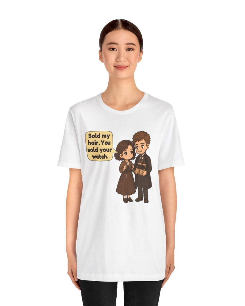 May include: A white t-shirt featuring a cartoon illustration of a couple. The female character has short brown hair and a brown dress, while the male character wears a dark suit. A speech bubble contains the text: Sold my hair. You sold your watch.