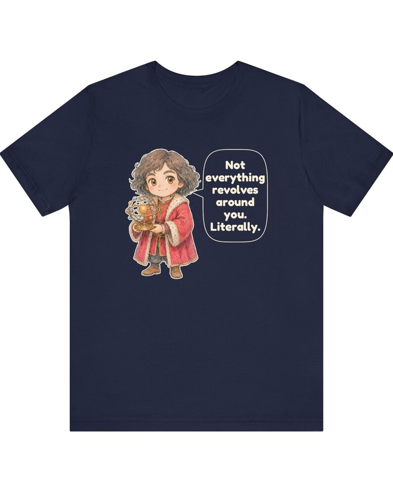 May include: A navy blue t-shirt featuring a cartoon illustration of a person with curly brown hair wearing a red coat and holding an armillary sphere. A speech bubble contains the text: Not everything revolves around you. Literally.