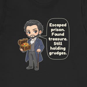 May include: A black t-shirt featuring a cartoon illustration of a bearded man in a blue coat holding a treasure chest filled with gold coins and gems. A speech bubble next to him contains the text: Escaped prison. Found treasure. Still holding grudges.