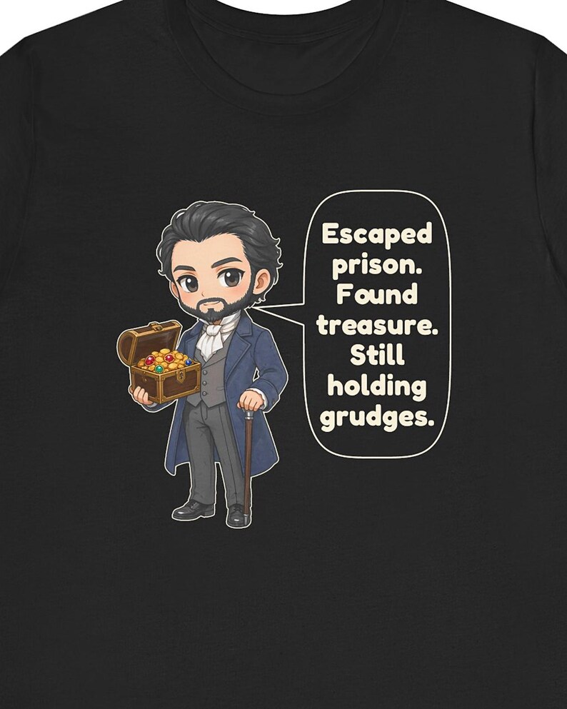 May include: A black t-shirt featuring a cartoon illustration of a bearded man in a blue coat holding a treasure chest filled with gold coins and gems. A speech bubble next to him contains the text: Escaped prison. Found treasure. Still holding grudges.