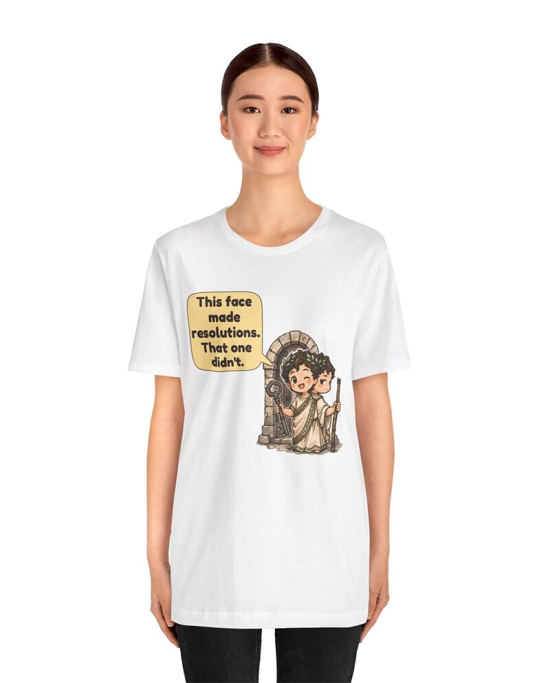 K&ouml;nnte beinhalten: Ein wei&szlig;es T-Shirt mit einer Grafik des zweigesichtigen r&ouml;mischen Gottes Janus vor einem Steinbogen. Ein Gesicht l&auml;chelt und h&auml;lt einen Schl&uuml;ssel, das andere wirkt ernst. Eine Sprechblase enth&auml;lt den Text: This face made resolutions. That one didn't.