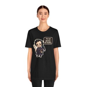 May include: A black t-shirt featuring a cartoon illustration of Edgar Allan Poe holding a quill and a book with a raven on his shoulder. A speech bubble next to the character contains the text: I'm not gloomy. I'm Gothic.