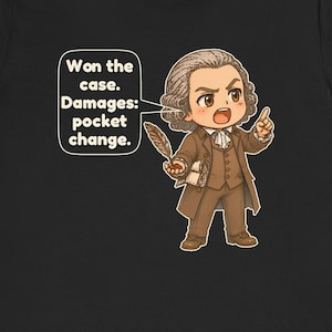 May include: A black t-shirt featuring a cartoon illustration of a person in 18th-century brown attire holding a quill and a scroll. A speech bubble contains the text: Won the case. Damages: pocket change.
