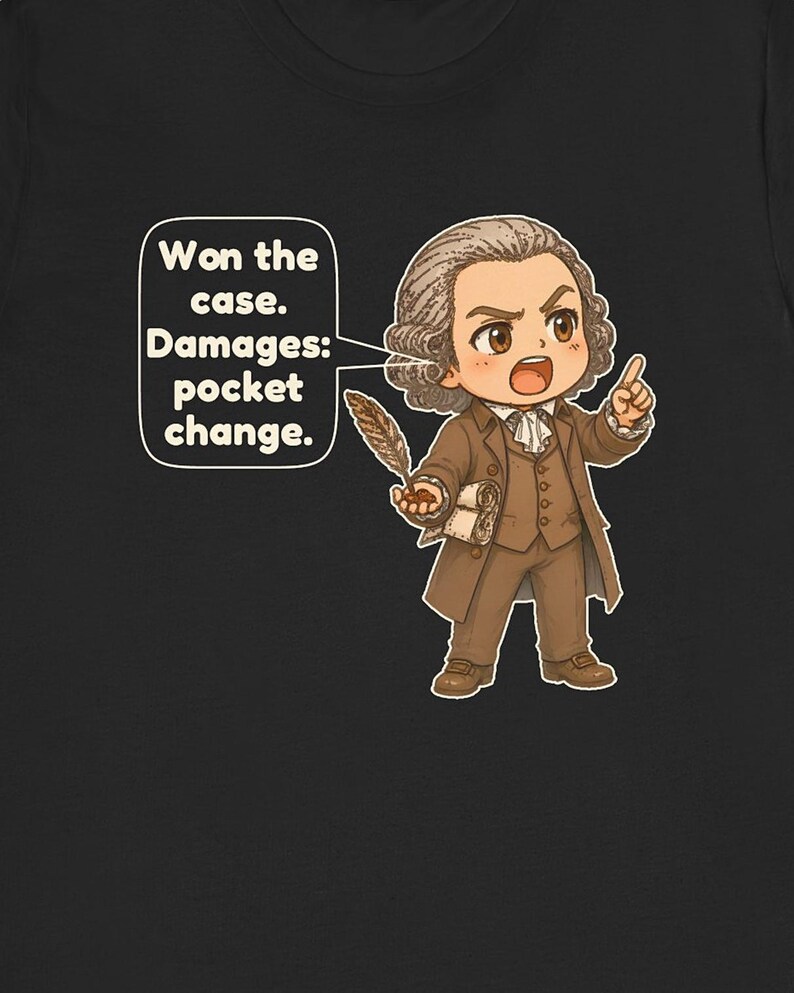 May include: A black t-shirt featuring a cartoon illustration of a person in 18th-century brown attire holding a quill and a scroll. A speech bubble contains the text: Won the case. Damages: pocket change.