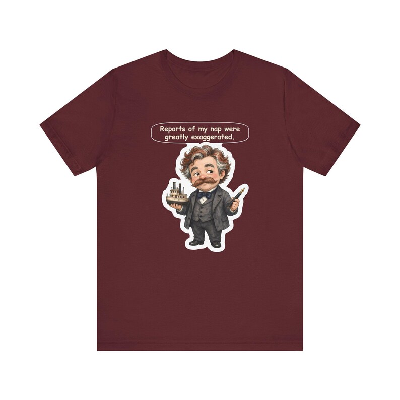 Watercolor chibi Mississippi riverboat author with a bushy moustache, navy bow tie and charcoal suit, holding a model riverboat and a fountain pen, with the speech bubble "Reports of my nap were greatly exaggerated." printed on a tee