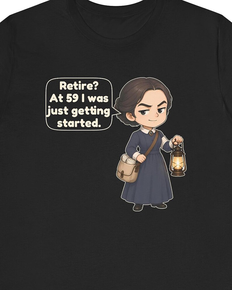 May include: A black t-shirt featuring a cartoon illustration of a person in a dark blue dress with a white collar, carrying a tan satchel and a lit lantern. A speech bubble contains the text: Retire? At 59 I was just getting started.