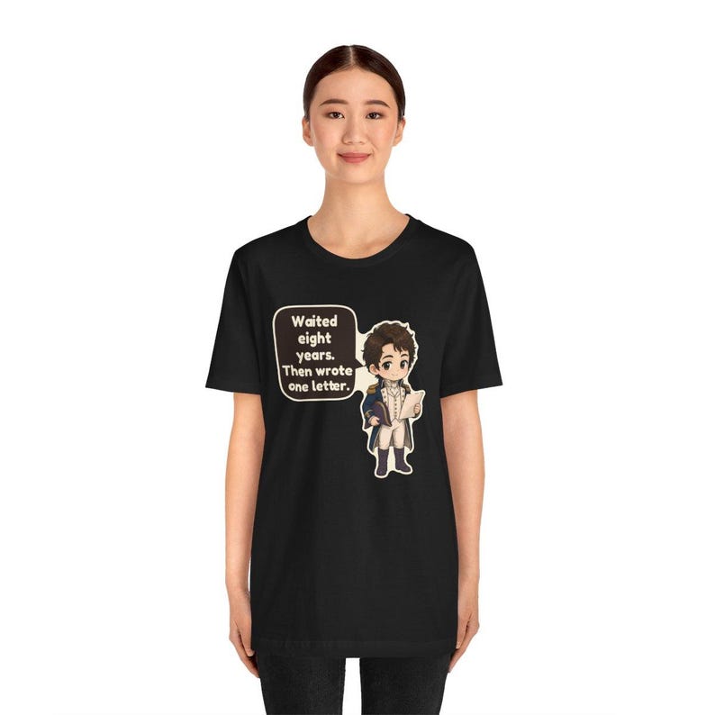 Puede incluir: Una camiseta negra de manga corta con un personaje de dibujos animados con uniforme militar azul y blanco que sostiene una carta. Un globo de texto junto al personaje contiene el texto: Waited eight years. Then wrote one letter.