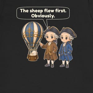 May include: A black t-shirt featuring a graphic of two figures in 18th-century attire standing next to a blue and white hot air balloon with a sheep in the basket. A speech bubble above contains the text: The sheep flew first. Obviously.