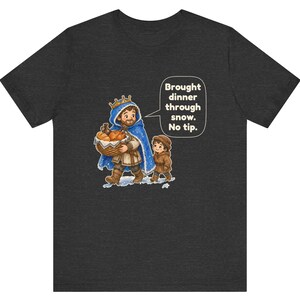 May include: A charcoal gray t-shirt featuring a graphic of a king in a blue cloak carrying a basket of bread with a child. A speech bubble contains the text: Brought dinner through snow. No tip. The illustration depicts a snowy scene.
