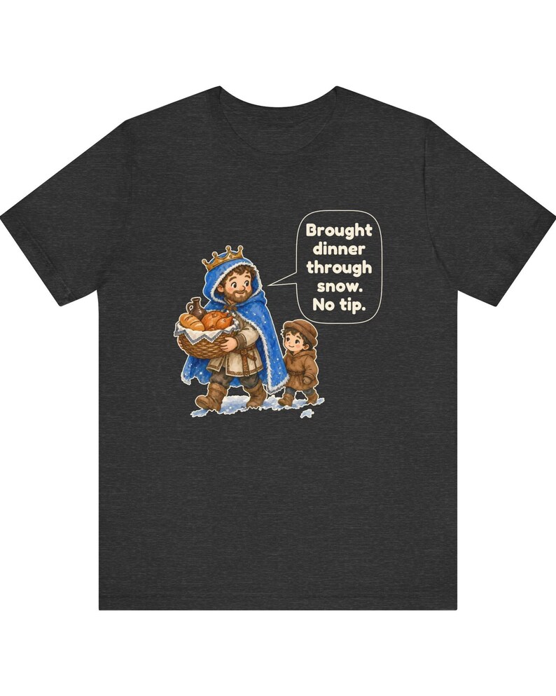 May include: A charcoal gray t-shirt featuring a graphic of a king in a blue cloak carrying a basket of bread with a child. A speech bubble contains the text: Brought dinner through snow. No tip. The illustration depicts a snowy scene.