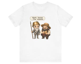 May include: A white t-shirt featuring a cartoon illustration of a knight in armor holding a spear and a person in a straw hat holding a sack. A speech bubble above them contains the text: Giants, Sancho! ...Fine, windmills.