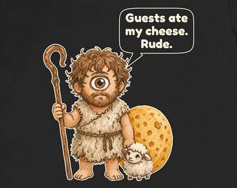 May include: A black t-shirt featuring a cartoon cyclops holding a wooden staff and standing next to a small sheep and a large wheel of Swiss cheese. A speech bubble above the cyclops contains the text: Guests ate my cheese. Rude.