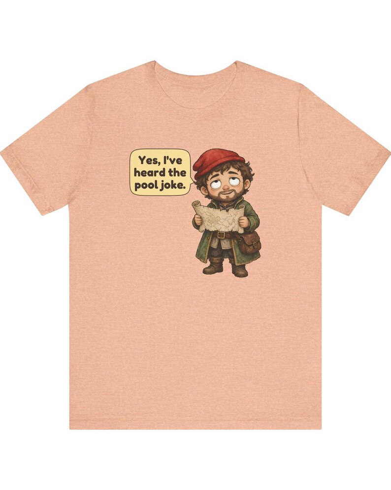 May include: A peach-coloured t-shirt featuring a cartoon illustration of a bearded character in a red cap and green coat holding a map. A speech bubble above the character contains the text, "Yes, I've heard the pool joke."