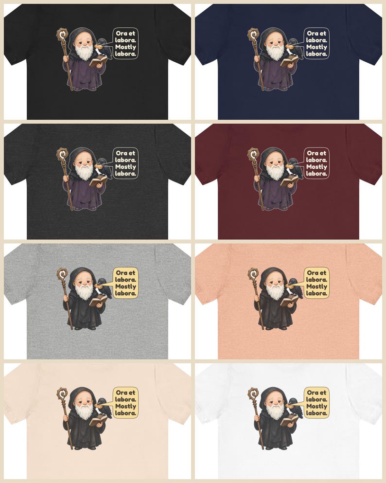 May include: A collection of eight t-shirts in various colors, each featuring a graphic of a bearded monk holding a staff and a book, with a raven perched on their shoulder. A speech bubble contains the text: Ora et labora. Mostly labora.