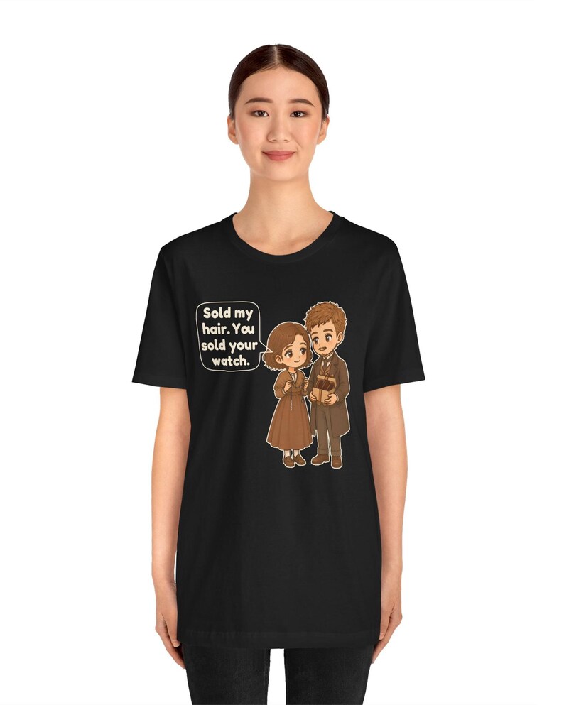May include: A black short-sleeve t-shirt featuring a cartoon illustration of two figures. One figure holds a box, and a speech bubble contains the text: Sold my hair. You sold your watch.
