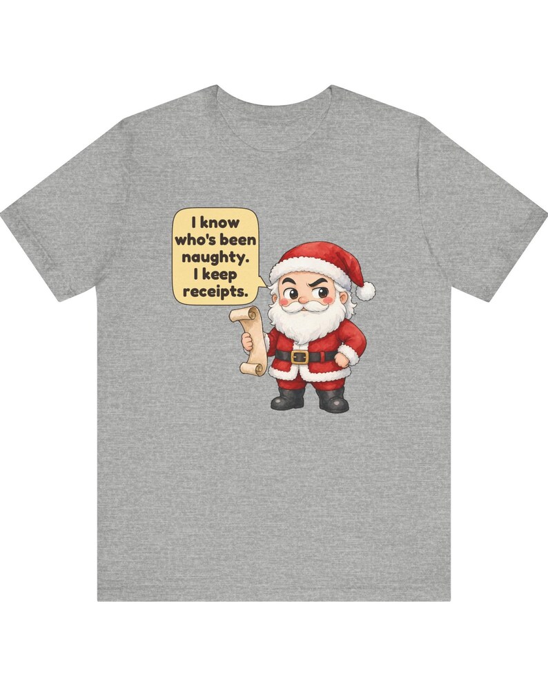 May include: A heather gray t-shirt featuring a cartoon Santa Claus holding a scroll. A yellow speech bubble next to him contains the black text: I know who's been naughty. I keep receipts. The Santa wears a red suit with white trim and black boots.