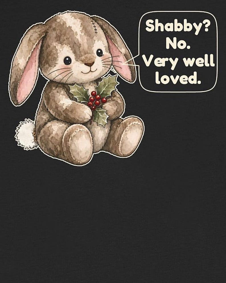 May include: A brown plush bunny with a white tail and pink inner ears holds a sprig of holly with red berries. A speech bubble next to the bunny contains the text: Shabby? No. Very well loved. The illustration is set against a dark background.