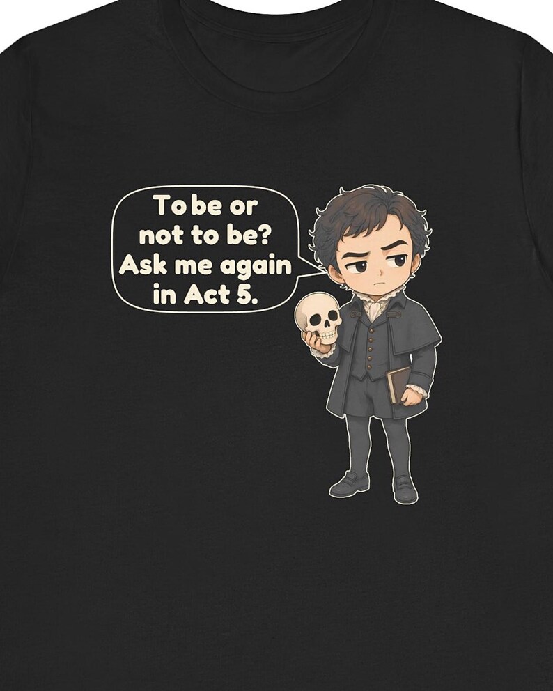 以下が含まれることがあります： 黒いTシャツに、暗い時代の服を着て頭蓋骨を持っている人物の漫画風イラストが描かれています。吹き出しには「To be or not to be? Ask me again in Act 5.」というテキストがあります。キャラクターは黒髪で本を持っています。