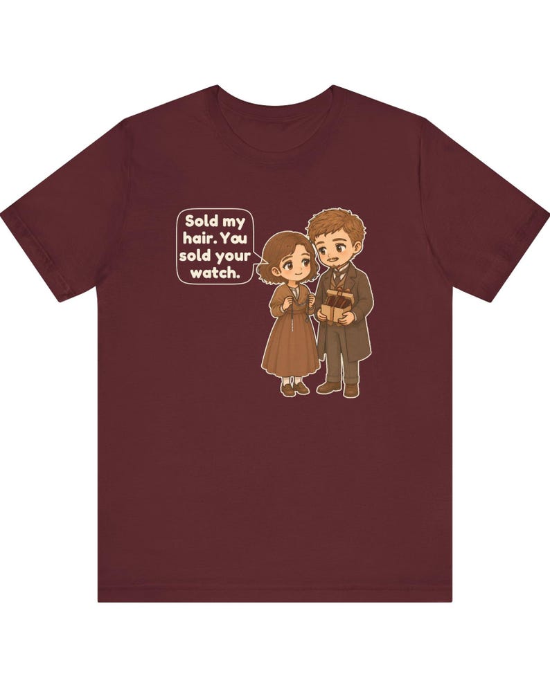 May include: A maroon short-sleeve t-shirt featuring a cartoon illustration of two people in brown clothing. A speech bubble contains the text: Sold my hair. You sold your watch. The characters are holding small gift boxes in their hands.