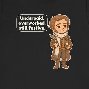 May include: A black t-shirt featuring a cartoon illustration of a person in a brown coat, white scarf, and boots, holding a quill and a candle. A speech bubble contains the text: Underpaid, overworked, still festive.