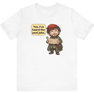 May include: A white t-shirt featuring a cartoon illustration of a bearded character wearing a red cap and green coat, holding a map. A speech bubble next to the character contains the text: Yes, I've heard the pool joke.