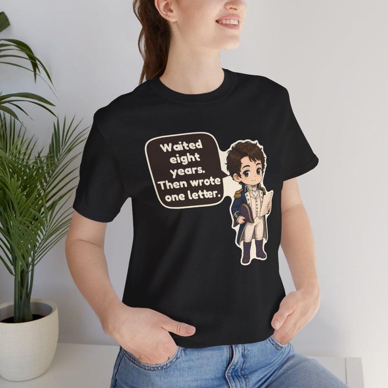 Puede incluir: Una camiseta negra de manga corta con una ilustraci&oacute;n de estilo dibujo animado de una persona con uniforme militar hist&oacute;rico sosteniendo una carta. Un globo de texto contiene el mensaje: Waited eight years. Then wrote one letter.
