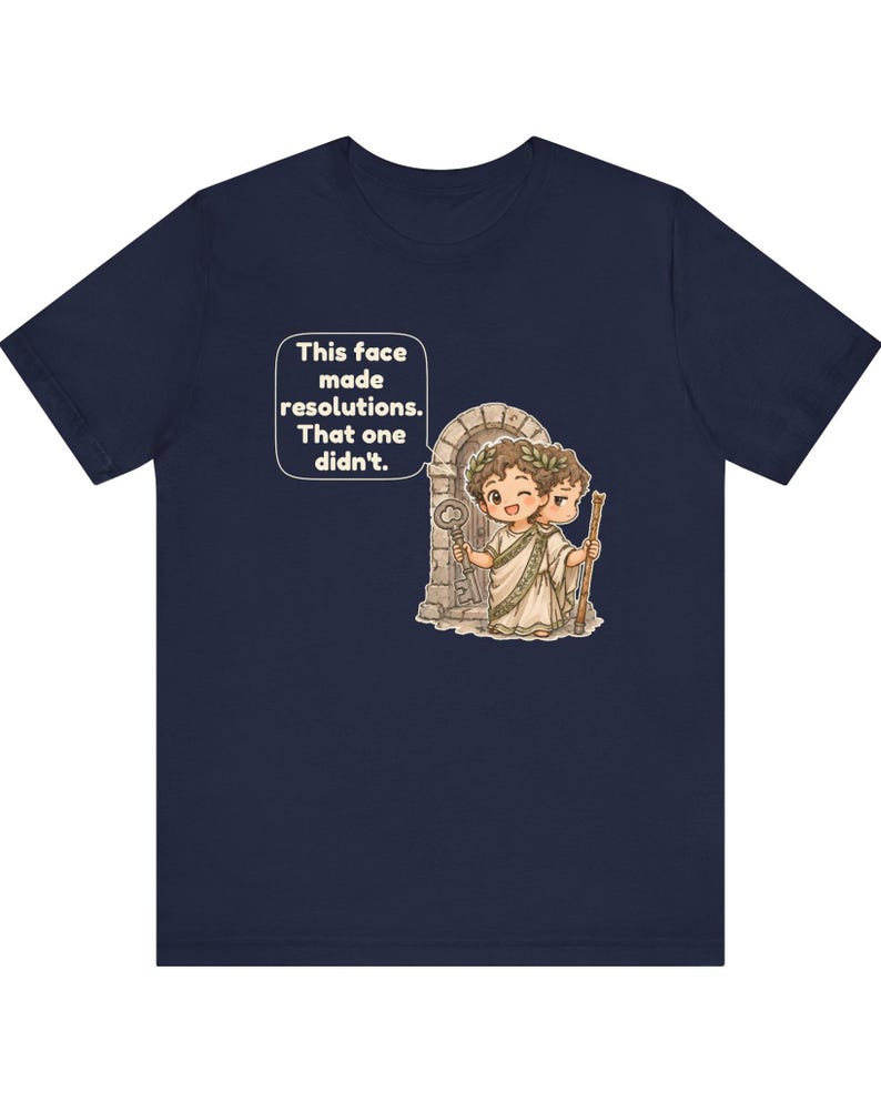 K&ouml;nnte beinhalten: Ein marineblaues T-Shirt mit einer Grafik einer r&ouml;mischen Figur mit zwei Gesichtern, die einen Lorbeerkranz tr&auml;gt und einen Schl&uuml;ssel sowie einen Stab vor einem Torbogen h&auml;lt. Eine Sprechblase enth&auml;lt den Text: This face made resolutions. That one didn't.