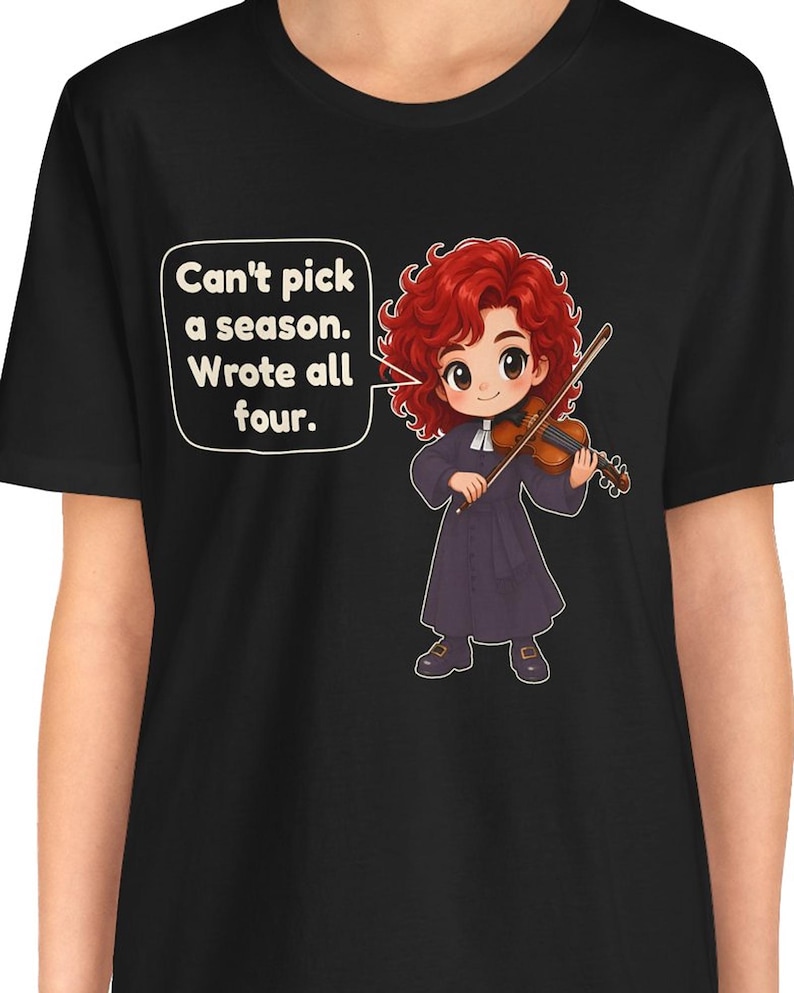 May include: A black t-shirt featuring a cartoon illustration of a red-haired violinist in a dark robe holding a violin. A speech bubble contains the text: Can't pick a season. Wrote all four. The design is centered on the front of the garment.