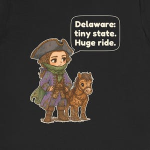 May include: A black t-shirt featuring a cartoon illustration of a person in a tricorn hat and purple coat standing next to a small brown horse. A speech bubble contains the text: Delaware: tiny state. Huge ride.