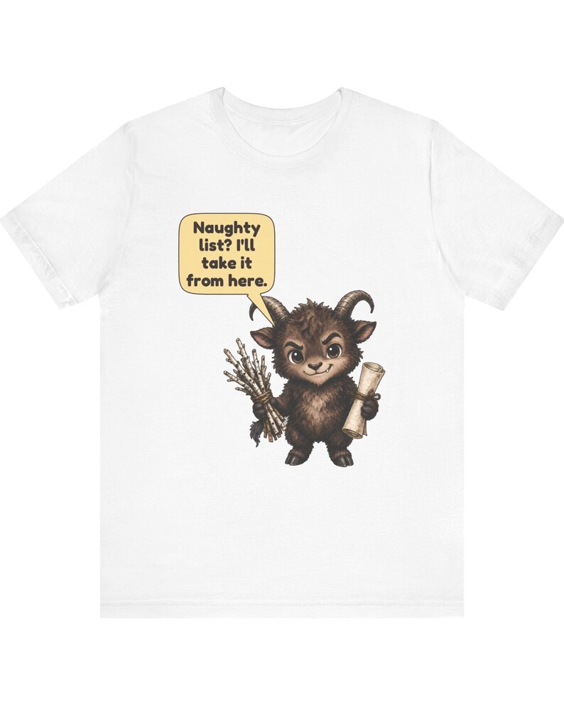 Puede incluir: Una camiseta blanca con el gr&aacute;fico de una criatura marr&oacute;n con cuernos que sostiene un manojo de palos y un pergamino. Un globo de texto sobre la criatura contiene el texto: Naughty list? I'll take it from here. El dise&ntilde;o est&aacute; centrado.