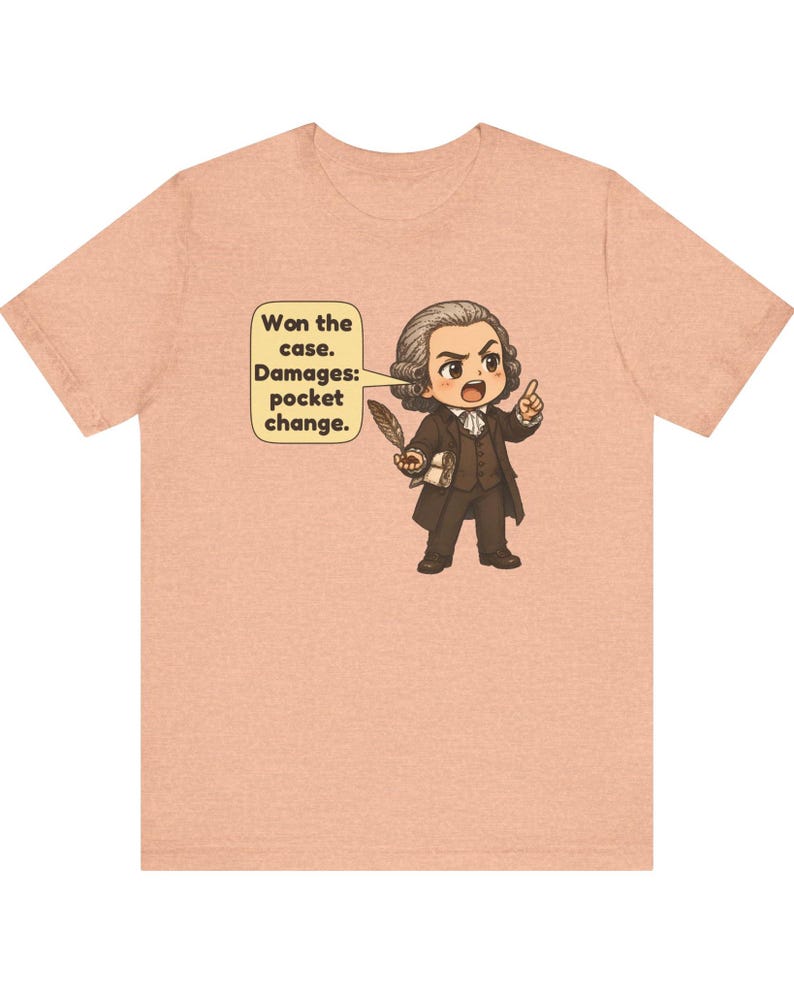 May include: A peach-colored t-shirt featuring a cartoon illustration of a historical figure in a brown suit holding a quill. A speech bubble contains the text: Won the case. Damages: pocket change. The design is centered on the chest.