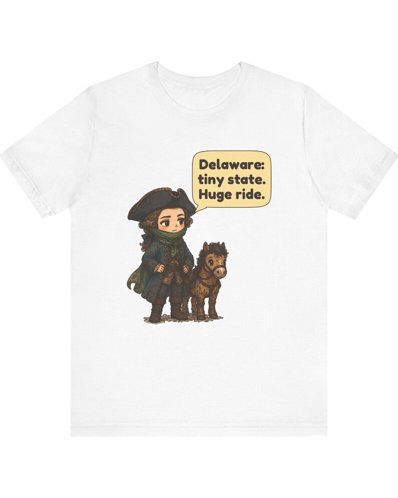 May include: A white t-shirt featuring a cartoon illustration of a person in a colonial-style hat and coat standing next to a small brown horse. A speech bubble above them contains the text: Delaware: tiny state. Huge ride.