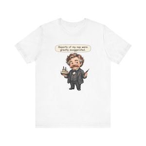 Watercolor chibi Mississippi riverboat author with a bushy moustache, navy bow tie and charcoal suit, holding a model riverboat and a fountain pen, with the speech bubble "Reports of my nap were greatly exaggerated." printed on a tee