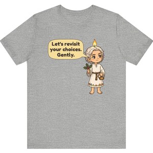 May include: A heather gray t-shirt featuring a cartoon character with a candle flame on their head, holding a sprig of holly and a small kettle. A speech bubble contains the text: Let's revisit your choices. Gently. The character wears a white tunic.