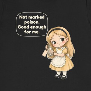 May include: A black t-shirt featuring a cartoon illustration of a blonde character in a yellow dress and white apron holding a glass bottle with a tag. A speech bubble above the character contains the text: Not marked poison. Good enough for me.