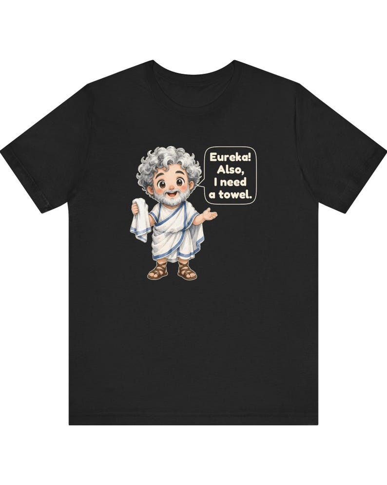 May include: A black t-shirt featuring a cartoon illustration of a bearded man with curly gray hair wearing a white toga and brown sandals. The character holds a white towel and has a speech bubble that reads, Eureka! Also, I need a towel.