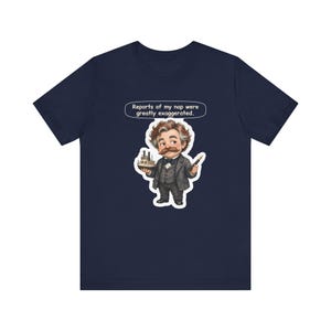Watercolor chibi Mississippi riverboat author with a bushy moustache, navy bow tie and charcoal suit, holding a model riverboat and a fountain pen, with the speech bubble "Reports of my nap were greatly exaggerated." printed on a tee